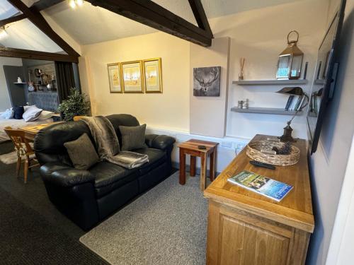 a living room with a couch and a table at Christmas Cottage in Doveridge