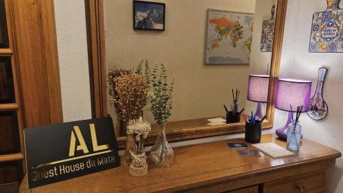 a wooden desk with vases and flowers on it at Guest House da Mata2 in Póvoa de Varzim