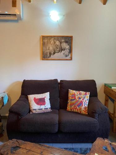 a brown couch in a living room with a picture on the wall at Adega Baia do Canto AL 1398 in Terra Alta