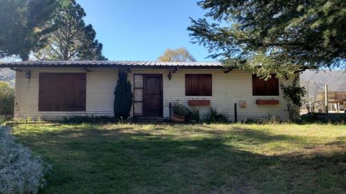an old white house with a tree in the yard at Casa tafi del valle in Tafí del Valle
