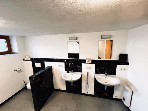 a bathroom with two sinks and two mirrors at Kinderparadies Alt Lüxem in Wittlich