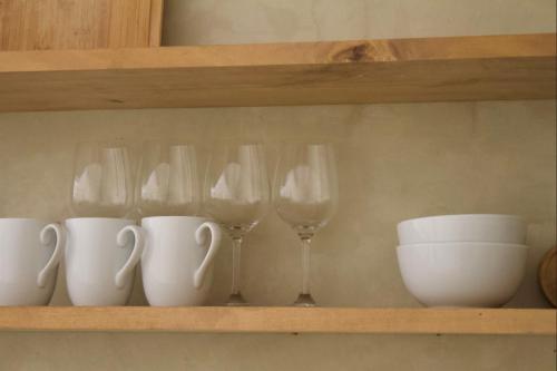 a shelf with wine glasses and bowls on it at Dannys Madiha in Godakanda