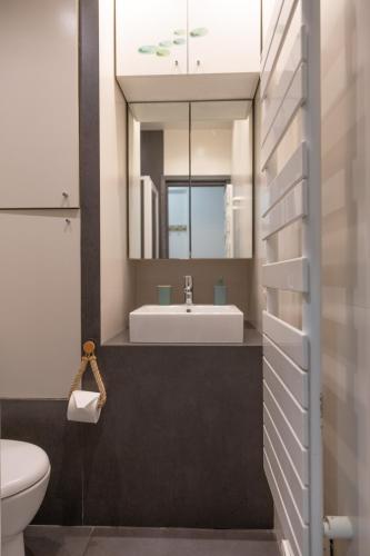 une salle de bain avec un lavabo et un miroir dans l'établissement Les Sablettes, à Menton