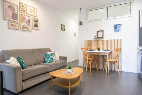 a living room with a couch and a table at Les Sablettes in Menton