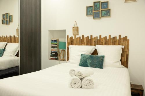 a bedroom with a white bed with towels on it at Les Sablettes in Menton