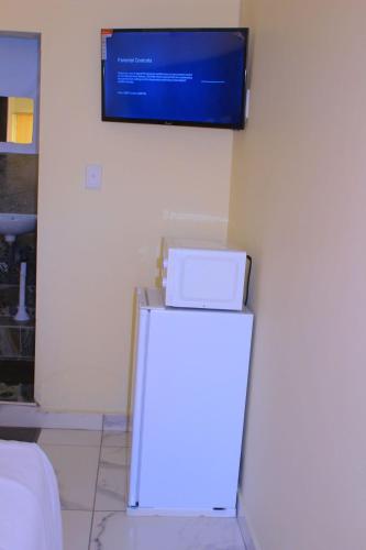 a white refrigerator with a television on the wall at Kitty Guest House in Bellville