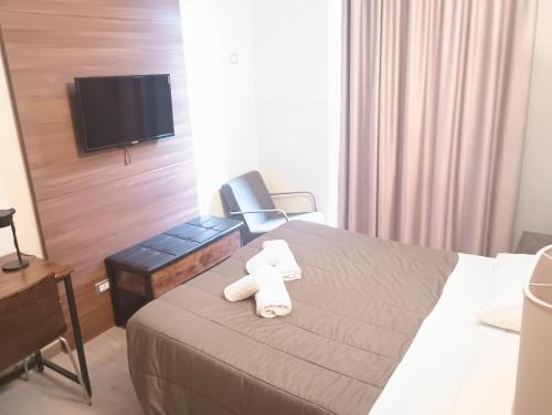 a hotel room with a bed with two towels on it at Hotel MM Dateo in Milan