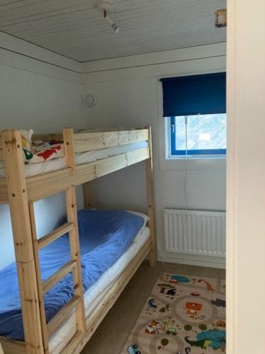 a bedroom with two bunk beds and a window at Stuga i Hällestrand, Strömstad in Strömstad
