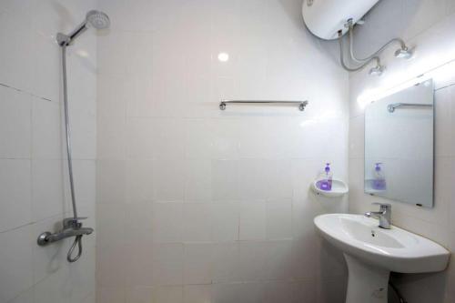 a white bathroom with a sink and a mirror at Green Meadows Farmhouse in Minazif