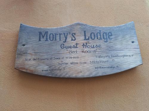 a sign hanging on the side of a building at Morry's Lodge Guest House in Sora