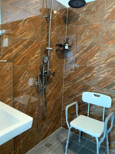 a shower with a sink and a chair in a bathroom at Mooncity Hotel & Boardinghouse in Frankfurt