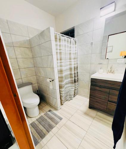 a bathroom with a toilet and a sink and a shower at Casa Orquídeas Oaxaca in Oaxaca City