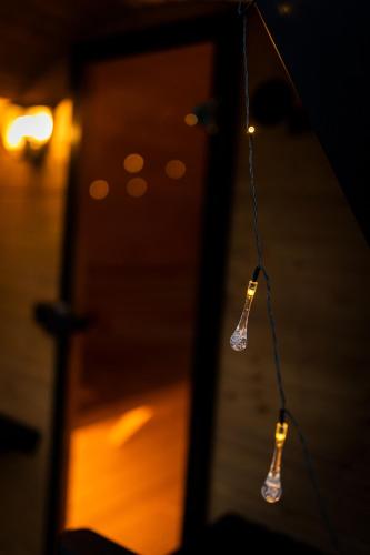 two lights hanging in front of a mirror at Beskid Loft House - domki w górach in Sól