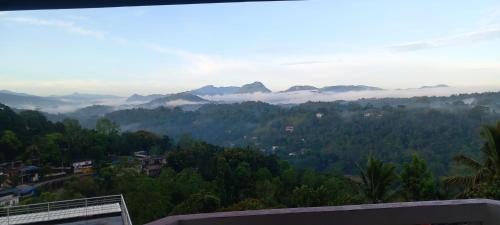 a view of a valley with clouds in the mountains at Mountain Bliss Villa Peradeniya in Peradeniya