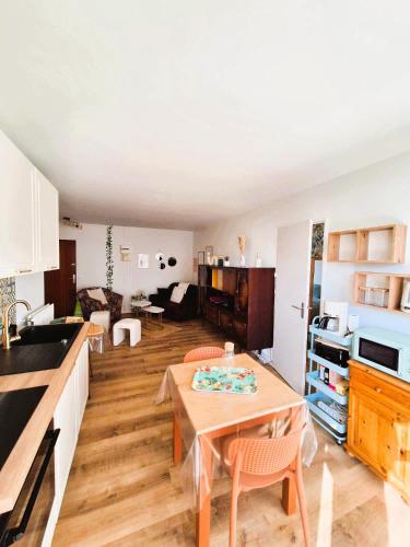 une cuisine et un salon avec une table dans une pièce dans l'établissement Le Cocon des Bluetwins, à Caen