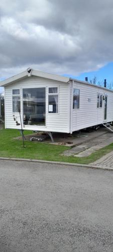 a mobile home is parked on the side of the road at Arual Caravan Manor House Park. Allonby, Cumbria in Maryport