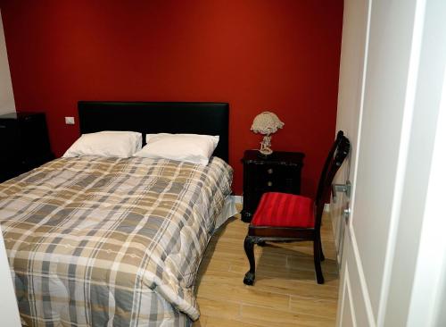 a bedroom with a bed and a red wall at Appia Antica Room in Marino