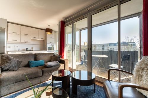 un salon avec un canapé et une grande fenêtre dans l'établissement Emplacement idéal, Garage privé, Lumineux, à Rennes