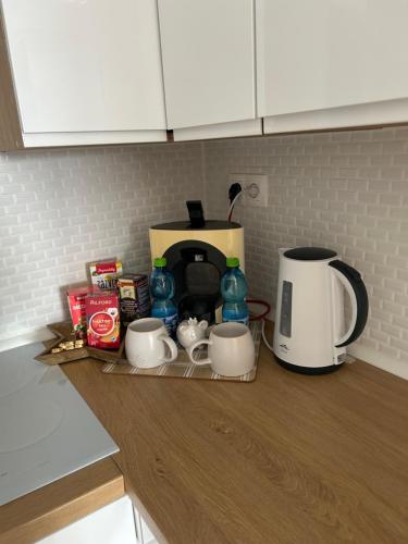 a kitchen counter with a coffee maker and cups and a toaster at Apartmán s parkovacím miestom in Nitra