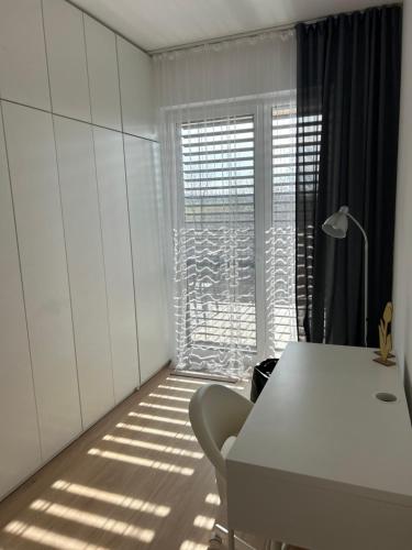 a white room with a table and a window at Apartmán s parkovacím miestom in Nitra