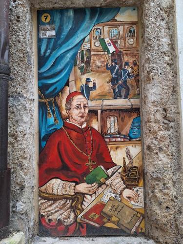 a painting of a pope on a wall at Morry's Lodge Guest House in Sora
