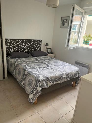 une chambre avec un lit avec une couette noire et blanche dans l'établissement The squadra with swimming pool, à Frontignan