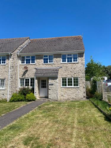 a large stone house with a yard at Garden Flat in West Lulworth in West Lulworth