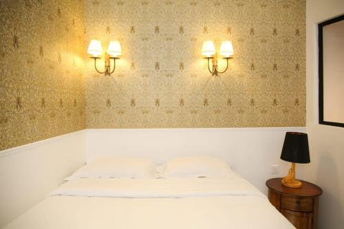 - une chambre avec un lit et deux lumières sur le mur dans l'établissement Magnifique appartement familial grand boulevard-6P, à Paris