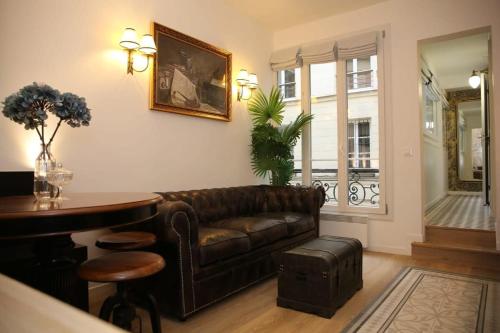 un salon avec un canapé en cuir et une table dans l'établissement Magnifique appartement familial grand boulevard-6P, à Paris