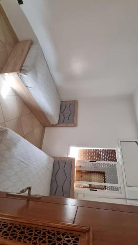 an attic room with a bed and a microwave at Appartement AL Matar 2 chambres et un salon in Nador