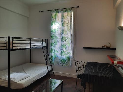 une chambre avec un lit superposé et une fenêtre dans l'établissement Appartement près des plages, à Nice