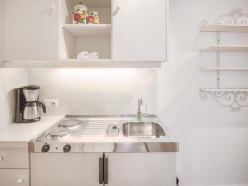 a white kitchen with a sink and a stove at Hotel Magdalena Mayrhofen in Mayrhofen
