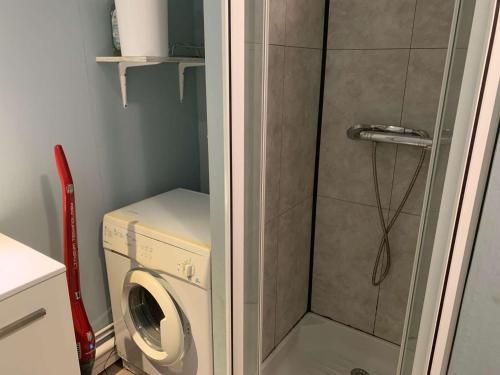 une machine à laver dans une salle de bain avec douche dans l'établissement Les Vagues du Marais - Saint hilaire de Riez, à Plage-des-Demoiselles