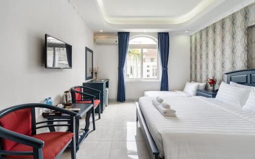 a hotel room with two beds and a window at La Casona Boutique Hotel in Ho Chi Minh City
