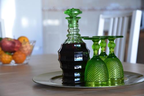 three green glass bottles on a plate on a table at Pro Touristic Casa Montejunto in Pereiro