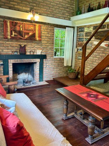 a living room with a fireplace and a wooden table at Casa de Mimbres in El Calafate