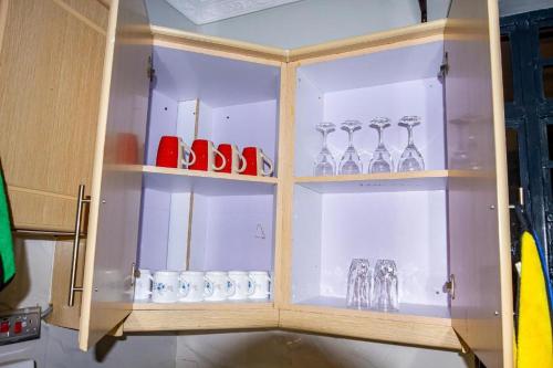 a wooden cabinet with glass items in it at Pthomes Official in Ruiru