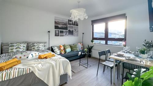 a bedroom with a bed and a table and a couch at Cosy stylish Duntocher flat near Glasgow in Clydebank