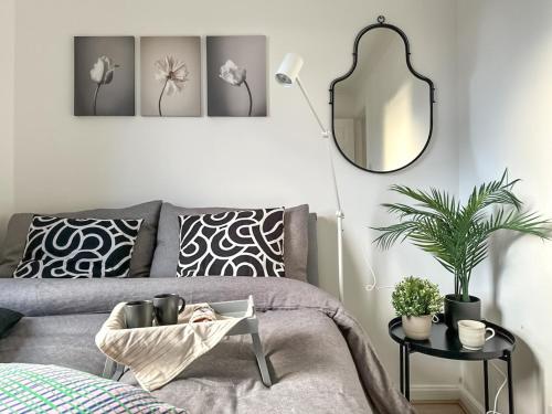 a living room with a gray couch and a mirror at Cosy stylish Duntocher flat near Glasgow in Clydebank