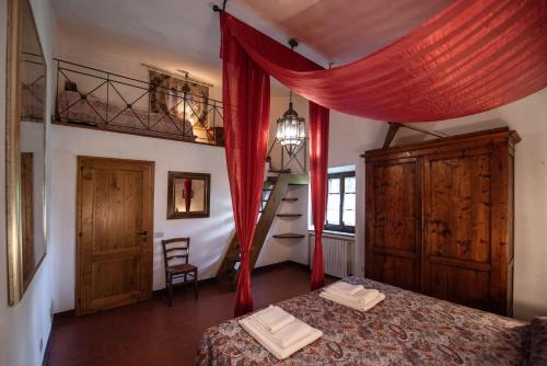 a bedroom with a bed with a red curtain at Green Hill Apartment In Tuscan Countryside in Siena