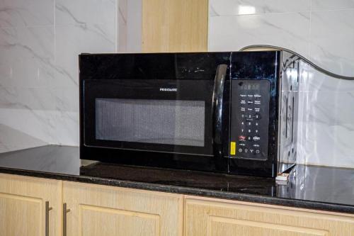 a microwave sitting on top of a kitchen counter at Pthomes Official in Ruiru