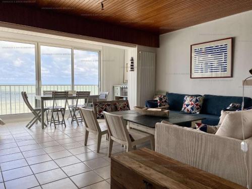 un salon avec un canapé, une table et des chaises dans l'établissement Bleu Marine Saint Gilles Croix de Vie, à Saint-Gilles-Croix-de-Vie