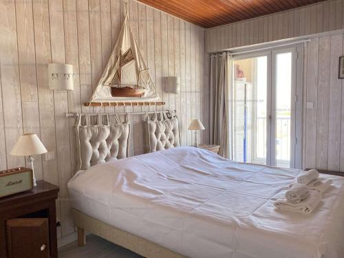 une chambre avec un grand lit blanc et une fenêtre dans l'établissement Bleu Marine Saint Gilles Croix de Vie, à Saint-Gilles-Croix-de-Vie