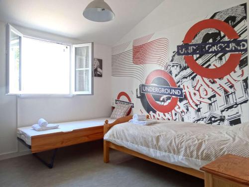 - une chambre avec un lit orné d'une fresque murale dans l'établissement Nausicaa Saint Gilles Croix de Vie, à Saint-Gilles-Croix-de-Vie