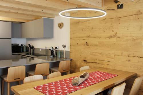 a kitchen and dining room with a table and chairs at ALPINE LOFT - Residence Veronza con piscina, Dolomiti Affitti in Cavalese