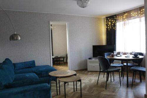 a living room with a blue couch and a table at City Center Turu str apartments, parking, Tartu Home in Tartu