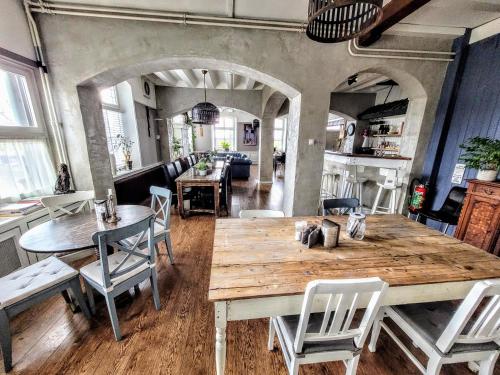 a dining room with a large wooden table and chairs at B&B De Grote Waaij in Well
