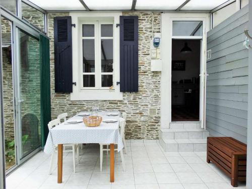 une table blanche et des chaises sur une terrasse dans l'établissement Hippocampe Saint Gilles croix de Vie, à Les Bussolleries