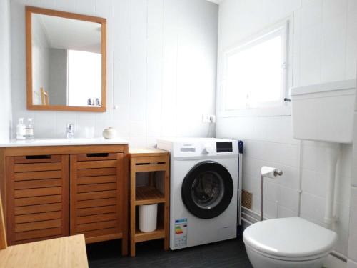 une salle de bain avec une machine à laver et un lavabo dans l'établissement Hippocampe Saint Gilles croix de Vie, à Les Bussolleries