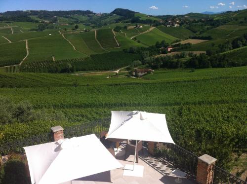 two white umbrellas sitting on a balcony overlooking a vineyard at Palas Cerequio in La Morra